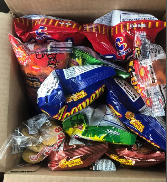 Box filled with various snack packets including Big foot and Tigaz.